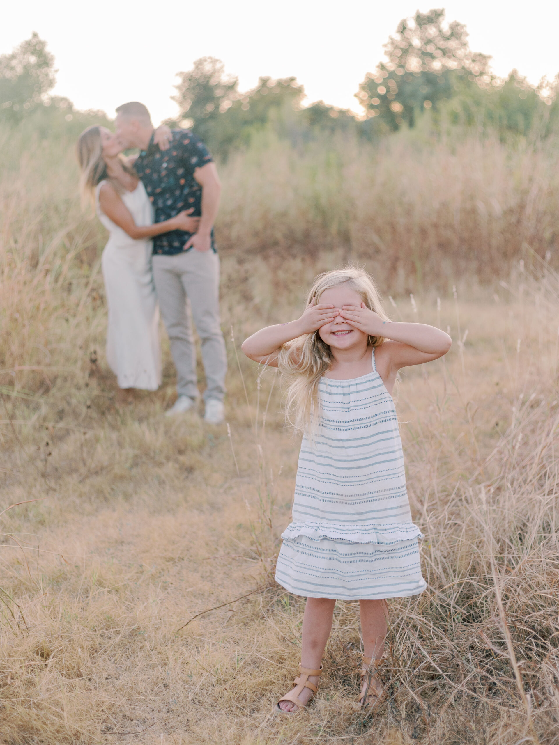 girl cover eyes mom and dad kissing