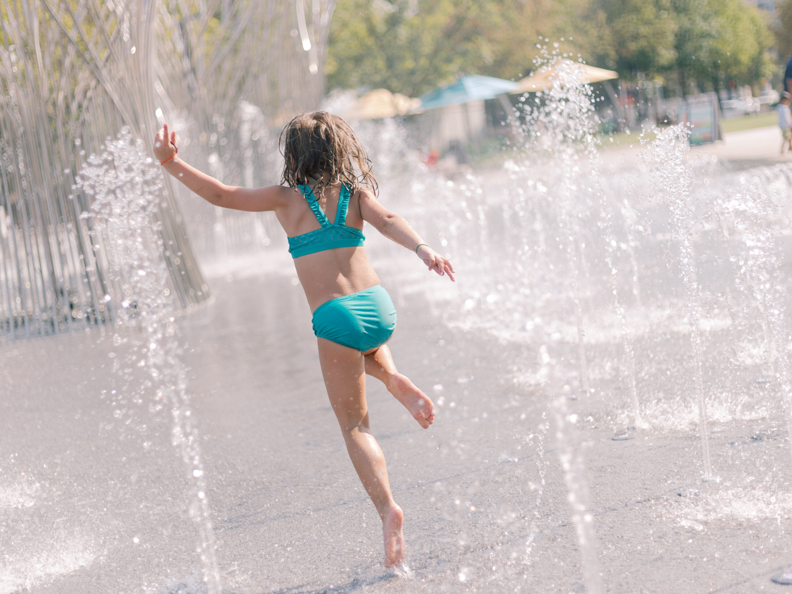 little girl playing in the fountain at Klyde Warren Park
