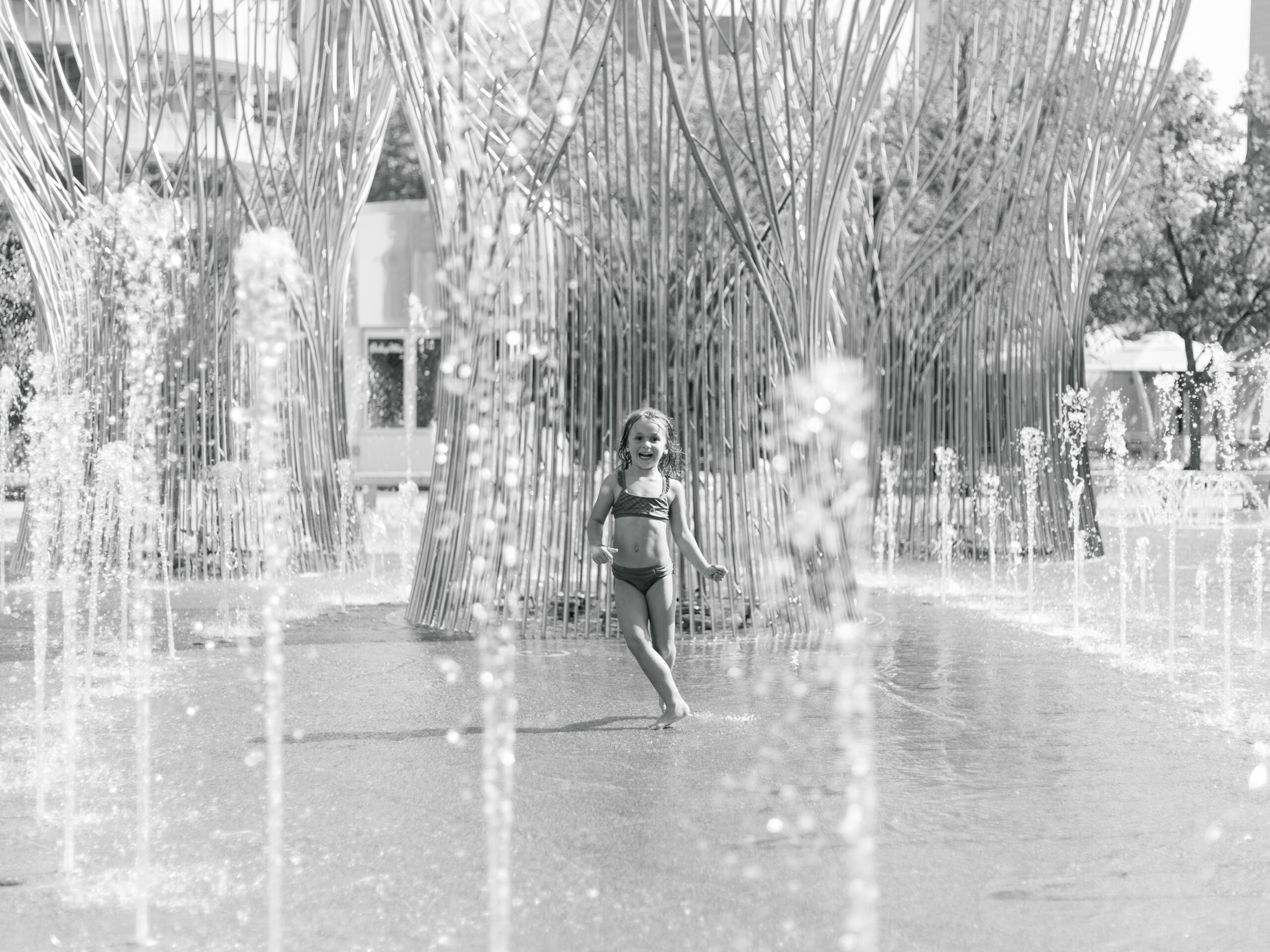 little girl playing in the fountain at Klyde Warren Park