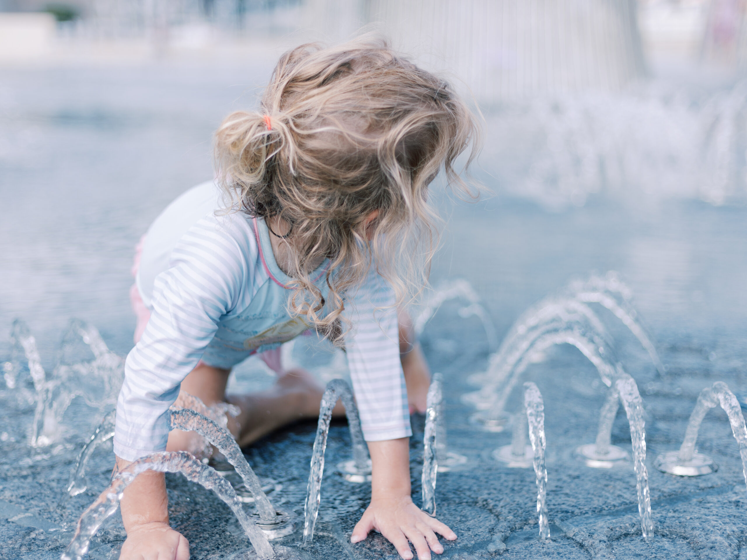little girl playing in the fountain at Klyde Warren Park