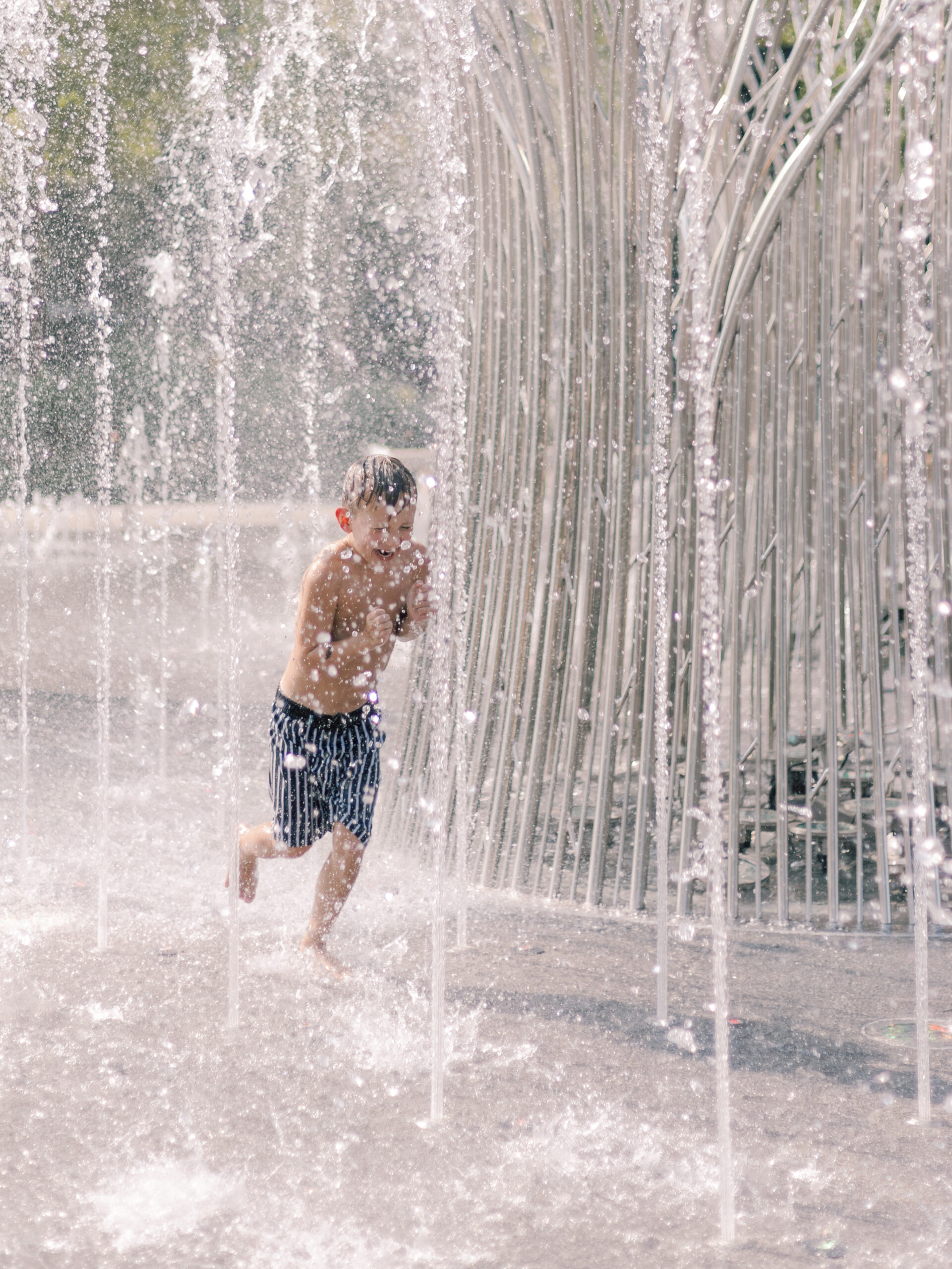 little boy playing in the fountain at Klyde Warren Park