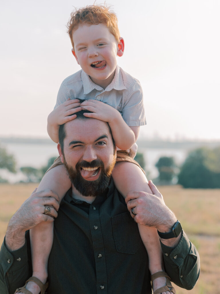 son on dad's shoulder sticking out tongues at Winfrey Point, Dallas