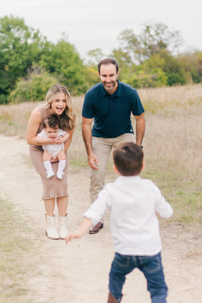 boy runs to mom and dad at Norbuck Park, Kate White Photography