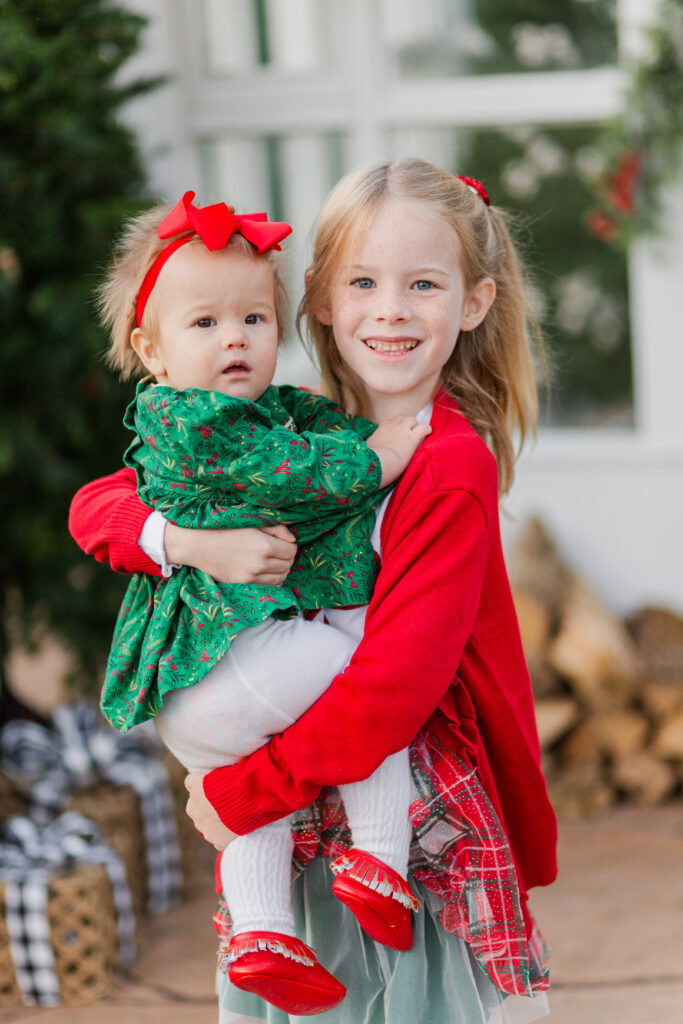 big sister holds baby sister at Lemon Drop Studios in McKinney TX by Kate White Photography