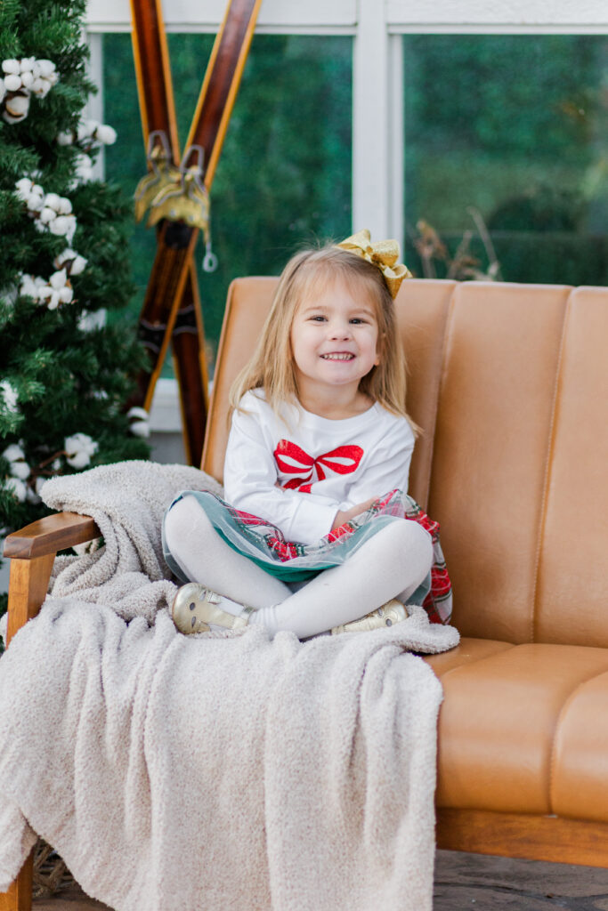 little sister sitting on couch at Lemon Drop Studios in McKinney TX by Kate White Photography