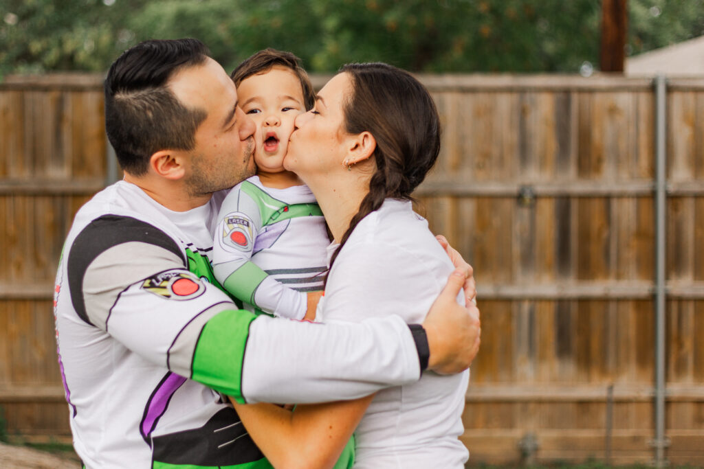 parents kiss baby at family birthday party by Kate White Photography