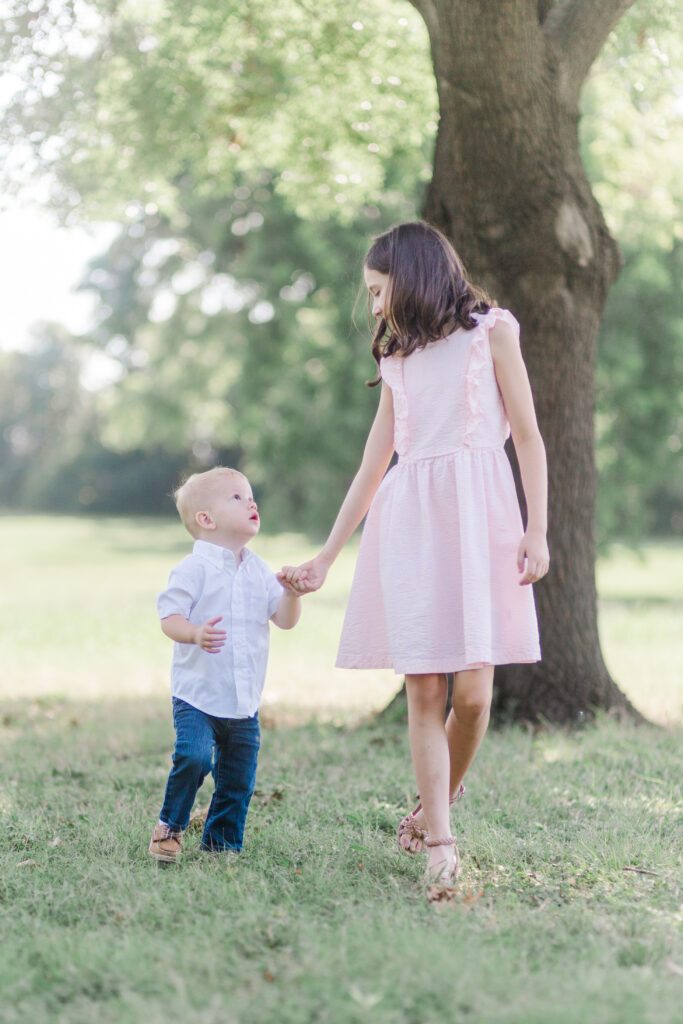 siblings walking at Harry S Moss Park in Dallas TX