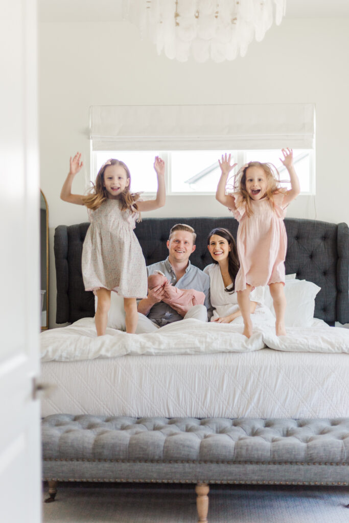 sisters jump on parents bed