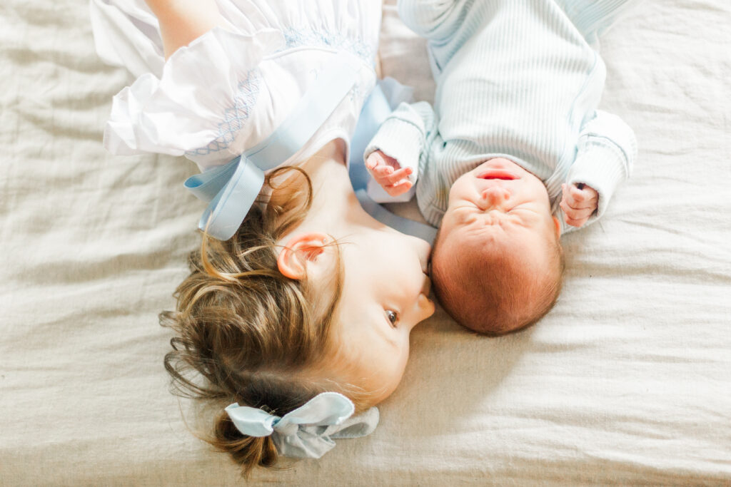 sister kisses baby brother