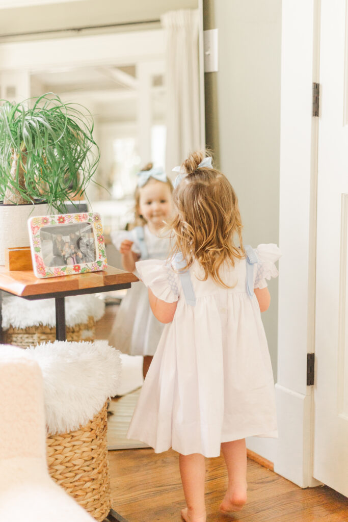 toddler girl looking at herself in the mirror