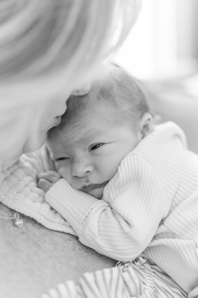 mom snuggling new baby in Dallas TX