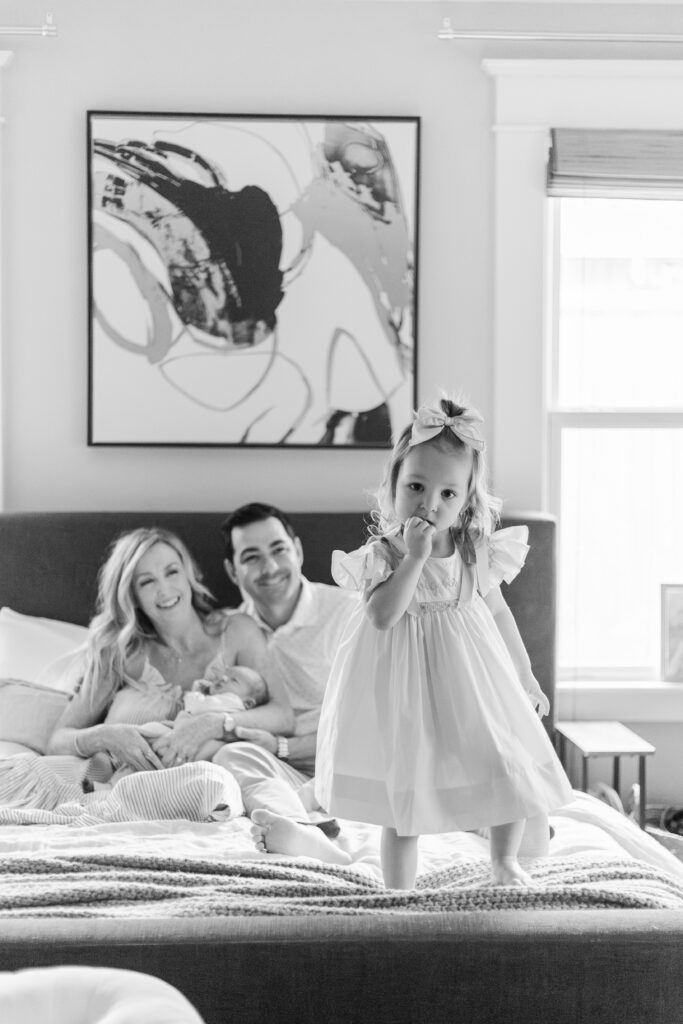 girl standing on parents bed