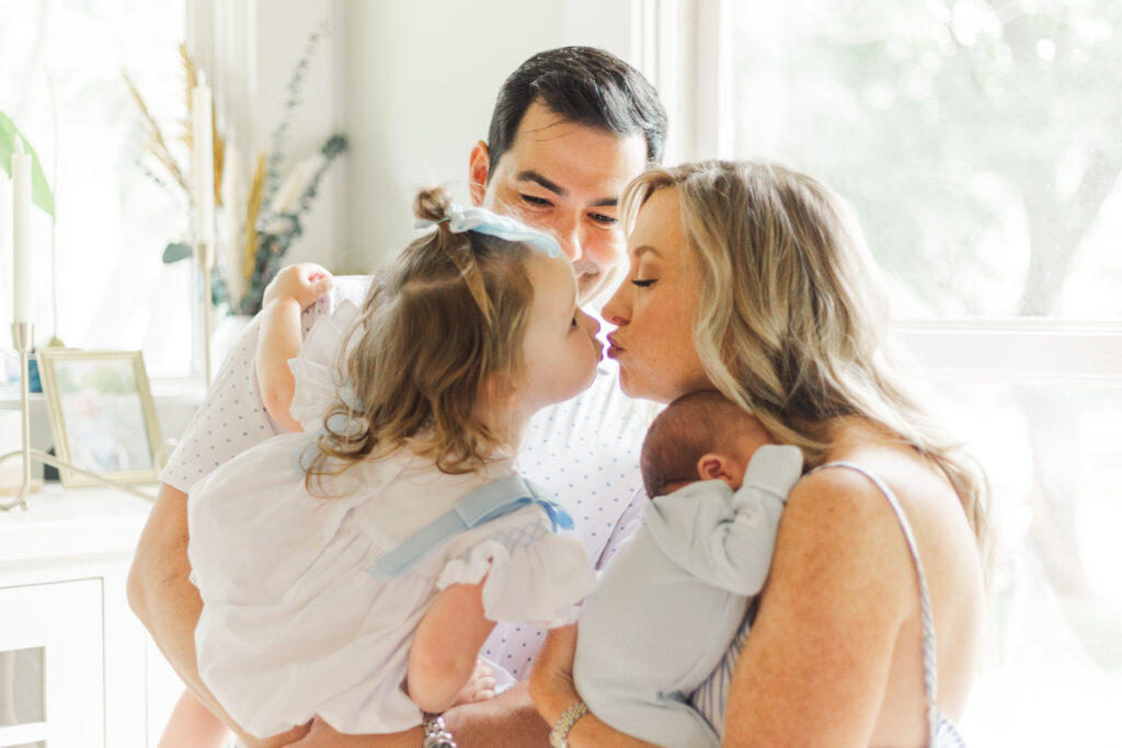 family snuggling new baby in Dallas TX