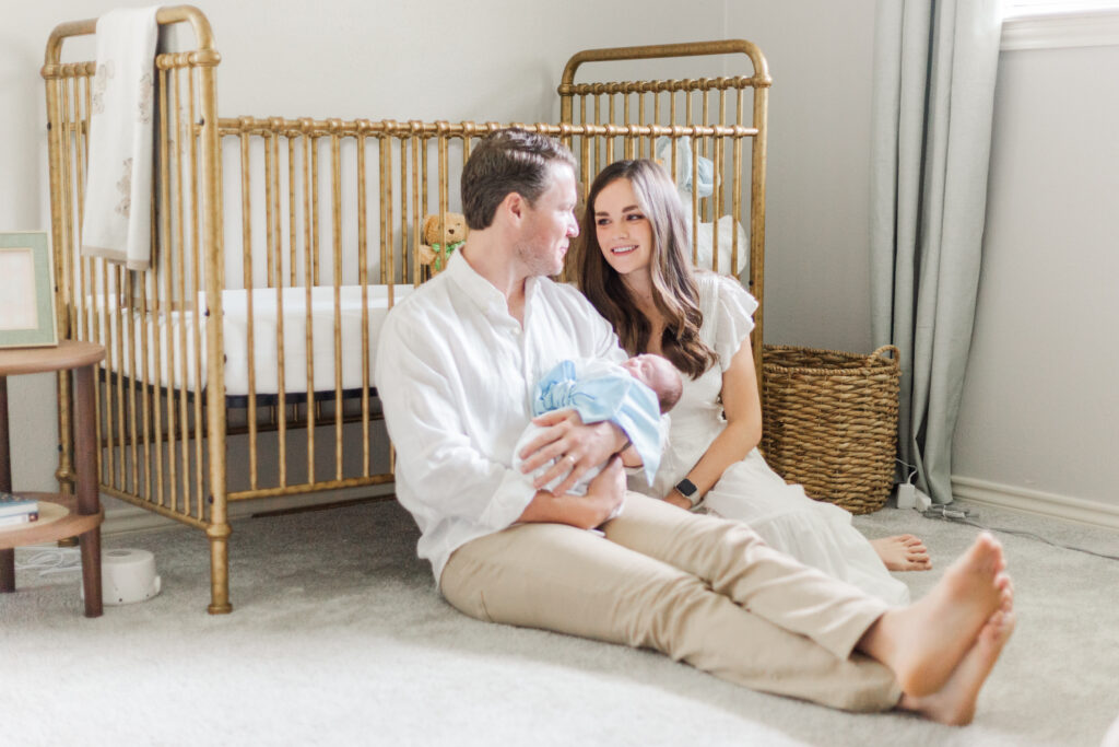 mom and newborn in front of crib in Dallas TX