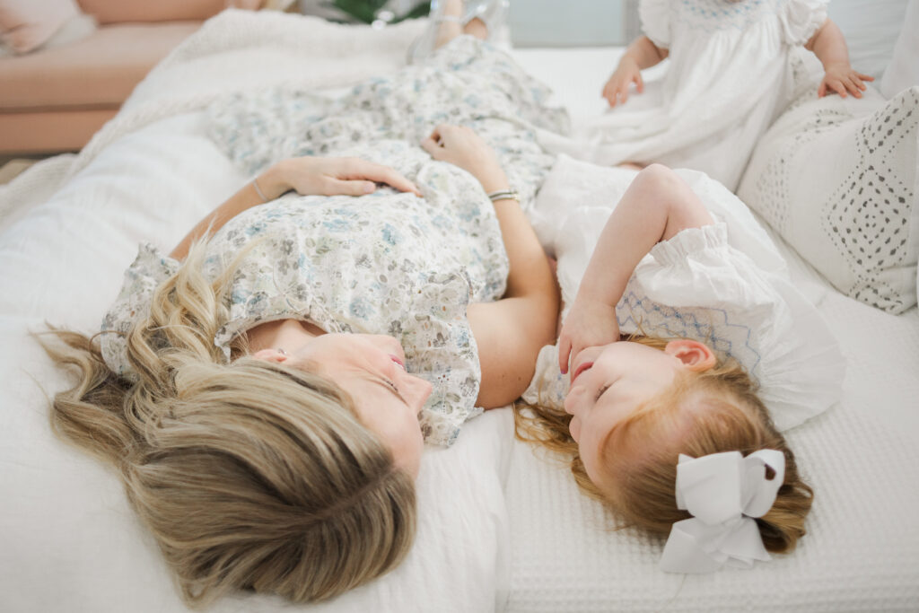 mom and daughter lying on bed in McKinney at the Beverley Harris House